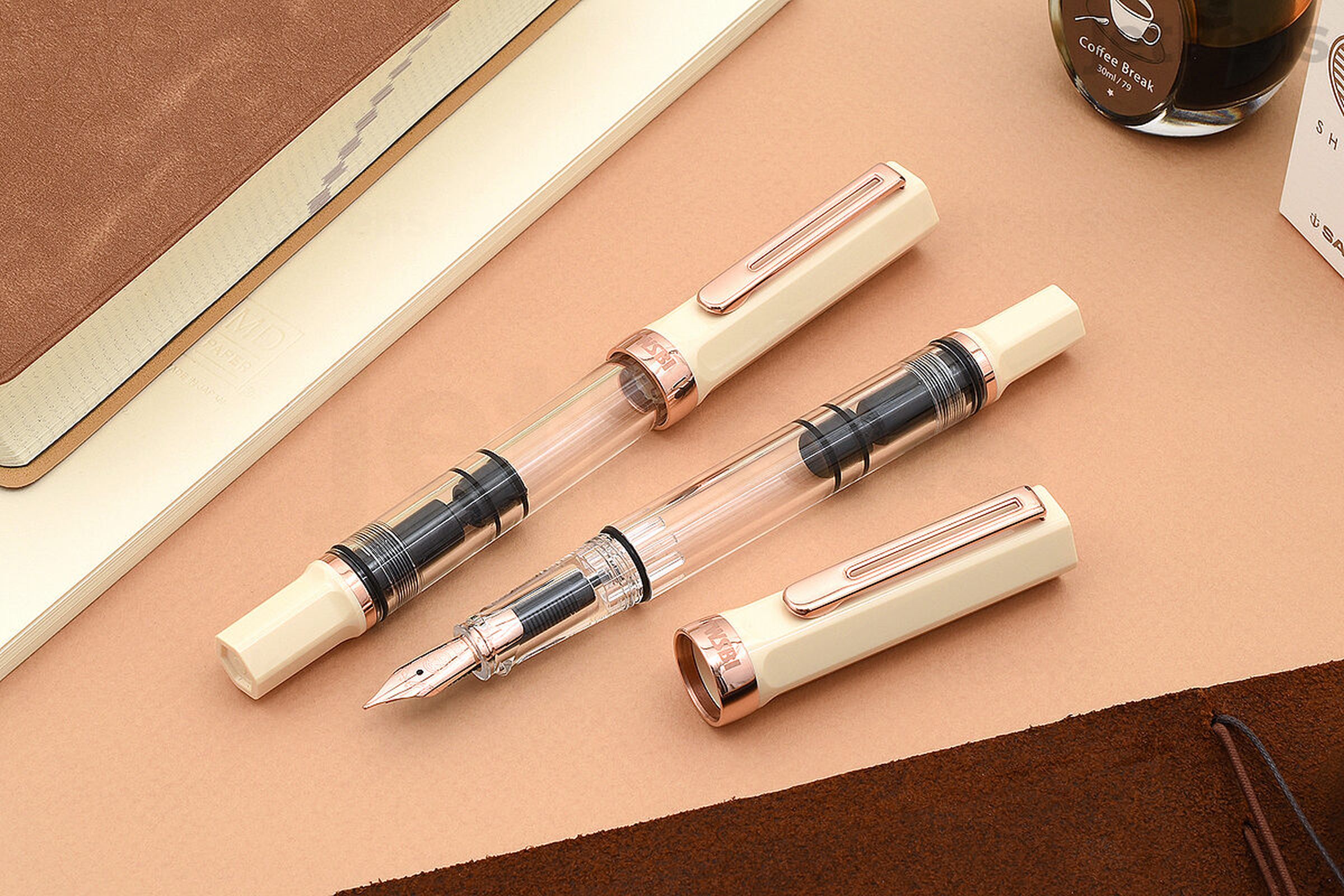 Rose-gold fountain pen in three pieces on table top.